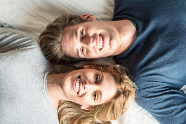beautiful happy young couple cuddling on bed